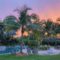 Landscape of a backyard with pool and cafe lights during sunset