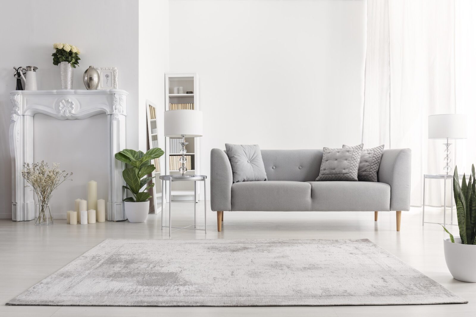 Plants and carpet in white living room interior with candles nex