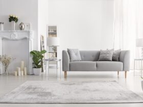 Plants and carpet in white living room interior with candles nex