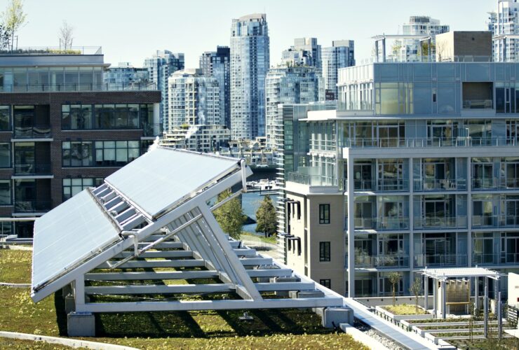 Solar Panel On Field By Buildings In City