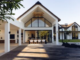 View of luxurious modern house exterior with dining space and garden