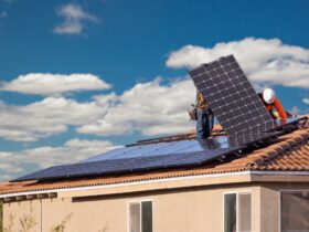 Workers Installing Solar Panels on House Roof