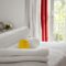 Beautifully and neatly folded white towels lie on the bed in the room against