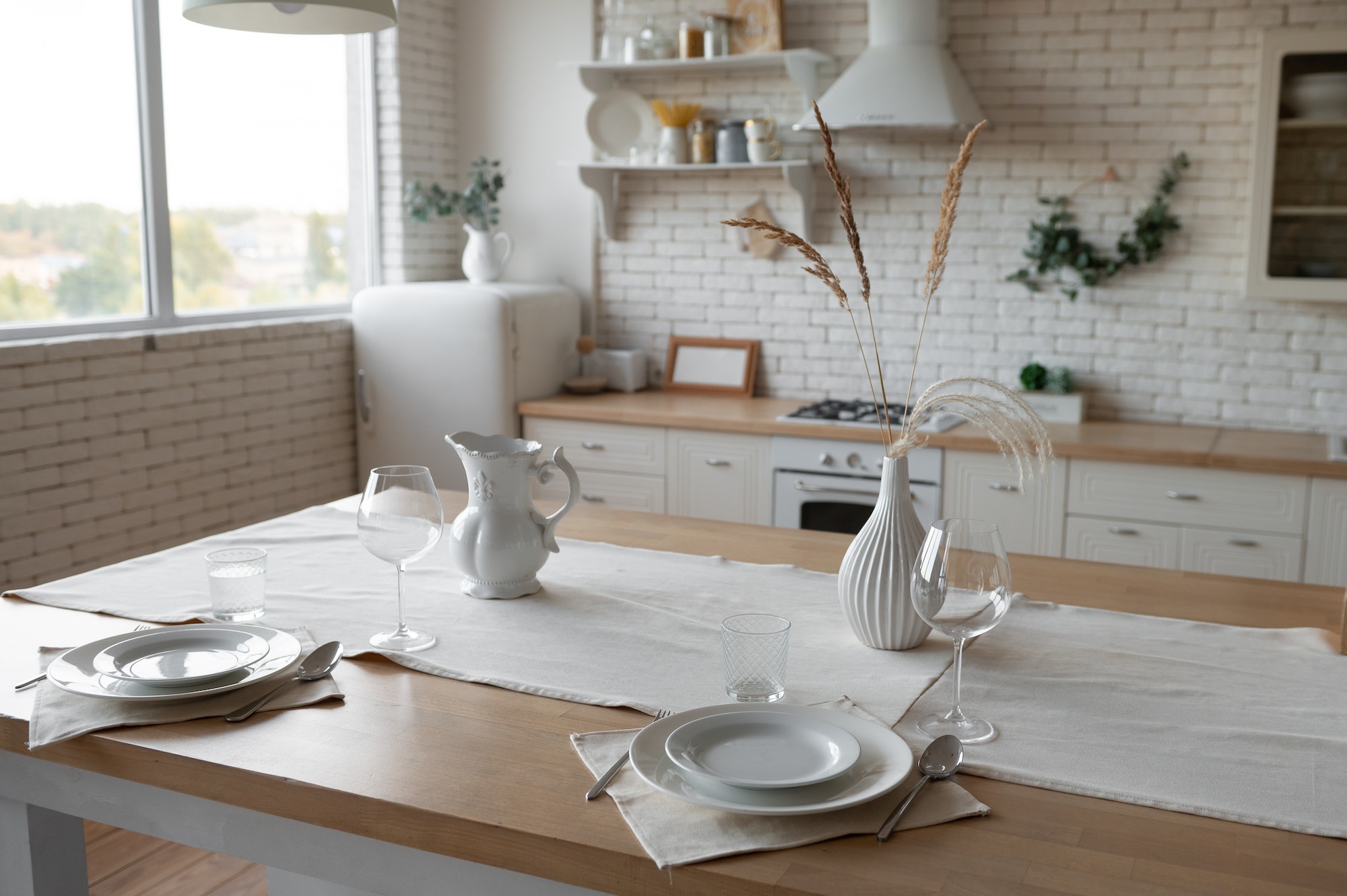 Modern bright scandi kitchen with decor and served table with dishes and plates