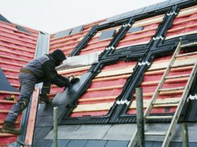 A roofer replacing the tiles on a house roof.