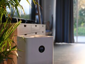 Air purifier with digital monitor screen and house plant in living room for fresh air.