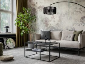 Industrial and loft living room interior with concrete wall, gray sofa, modern armchair,