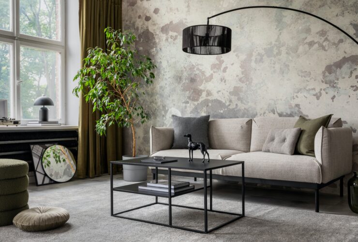 Industrial and loft living room interior with concrete wall, gray sofa, modern armchair,