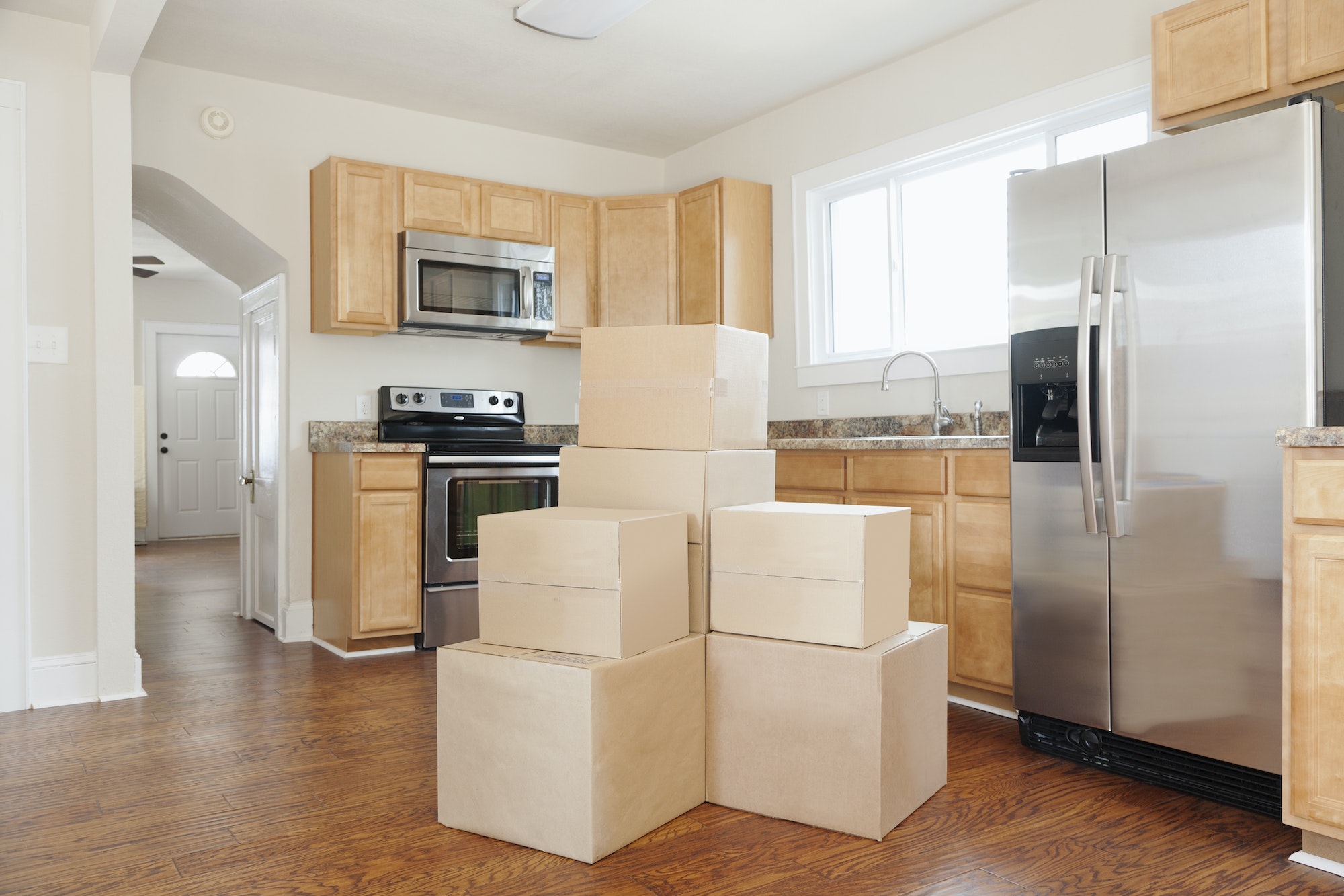 Moving house, relocation, cardboard boxes piled up in a house fitted kitchen