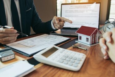 Property sales staff submit land mortgage contract documents to home buyers for sign.