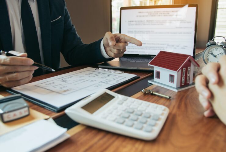 Property sales staff submit land mortgage contract documents to home buyers for sign.