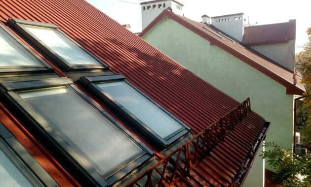 Red tiled house roof with attic windows. Roofing construction, window installation