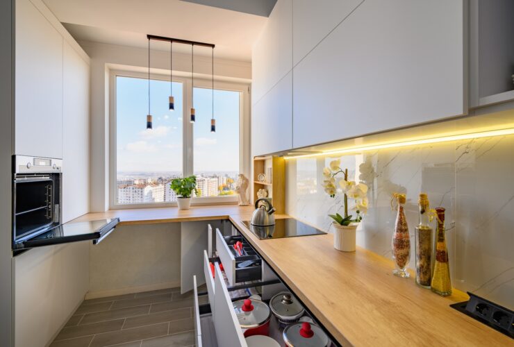 A sleek white kitchen with drawers extended