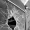 Broken Glass: Monochromatic image of shattered windshield of vintage car in old garage.