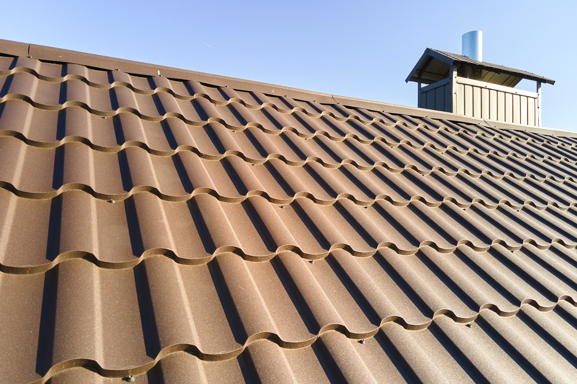 Closeup of house roof top covered with metallic shingles