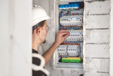 Electrical technician working in a switchboard with fuses. Installation and connection.