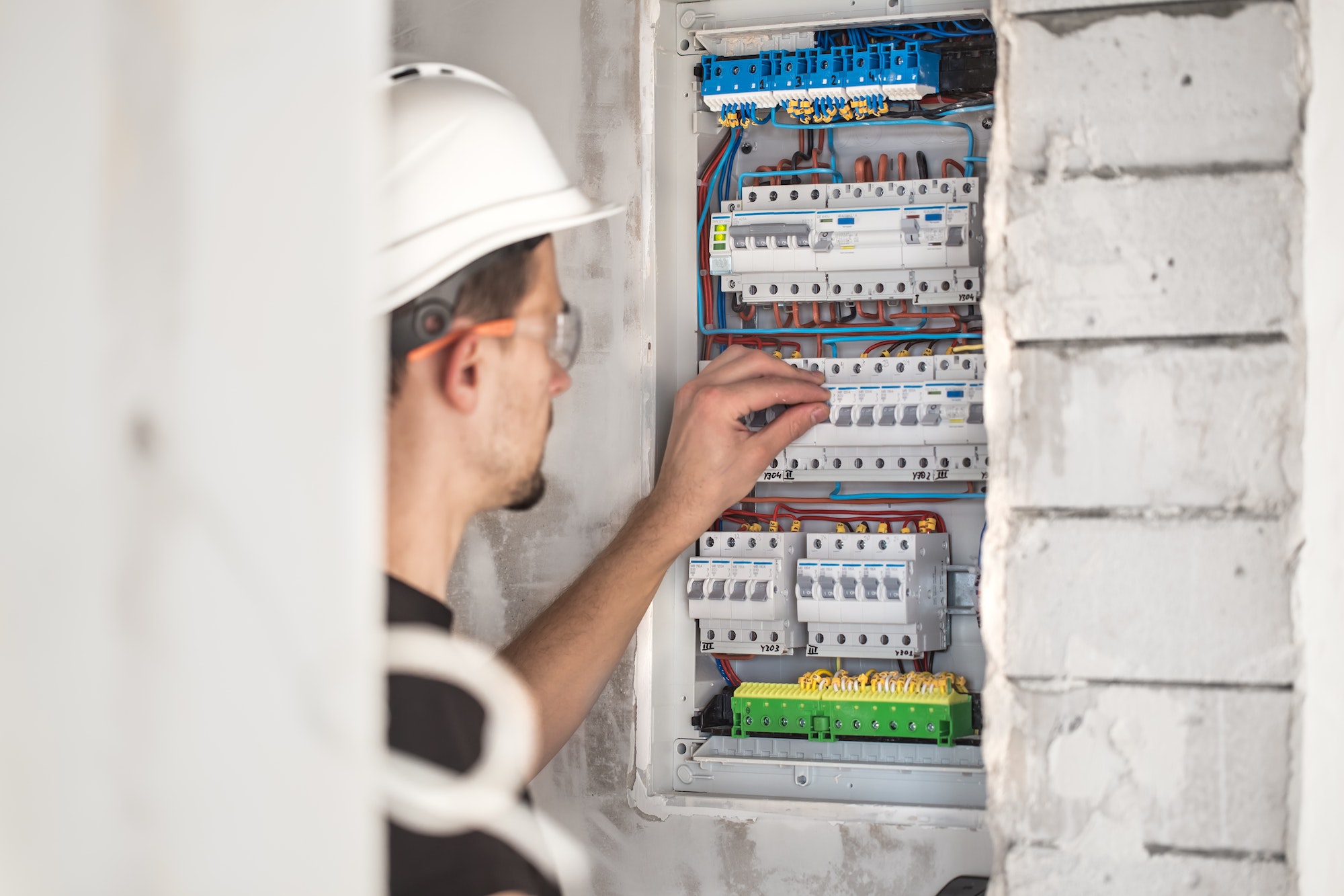 Electrical technician working in a switchboard with fuses. Installation and connection.