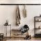 The stylish composition of cosy entryway with grey bench, black consola, hanger and lamp.