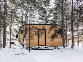 Wooden tiny house snowy winter forest. Glamping