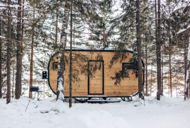 Wooden tiny house snowy winter forest. Glamping