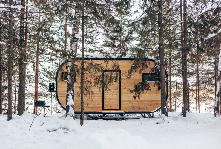 Wooden tiny house snowy winter forest. Glamping