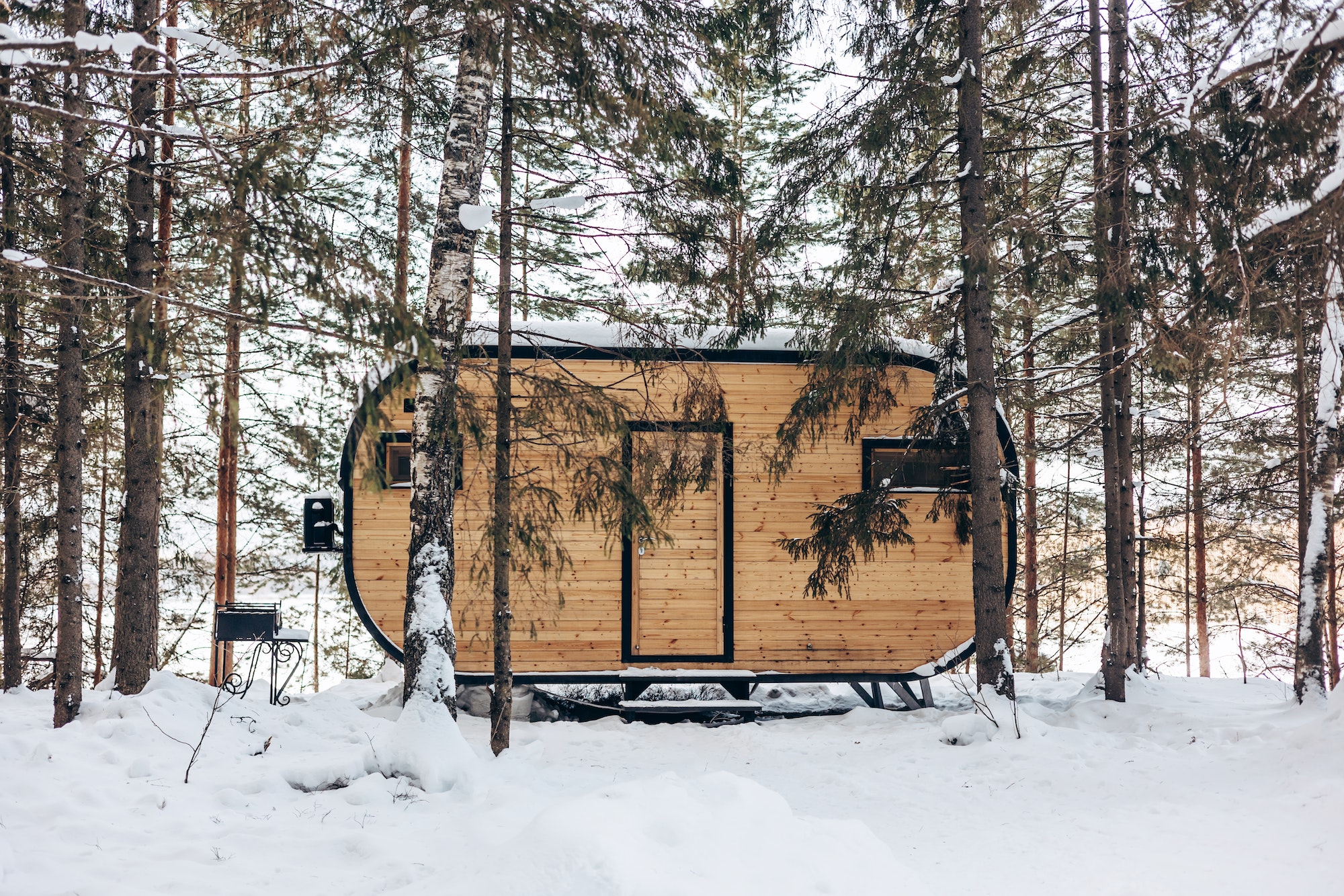 Wooden tiny house snowy winter forest. Glamping