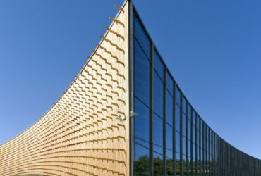 Modern university buildings, wooden beams projecting from a curved wood cladding