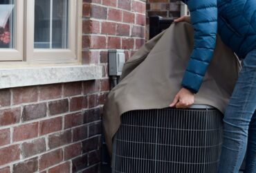 Putting cover on air conditioner unit