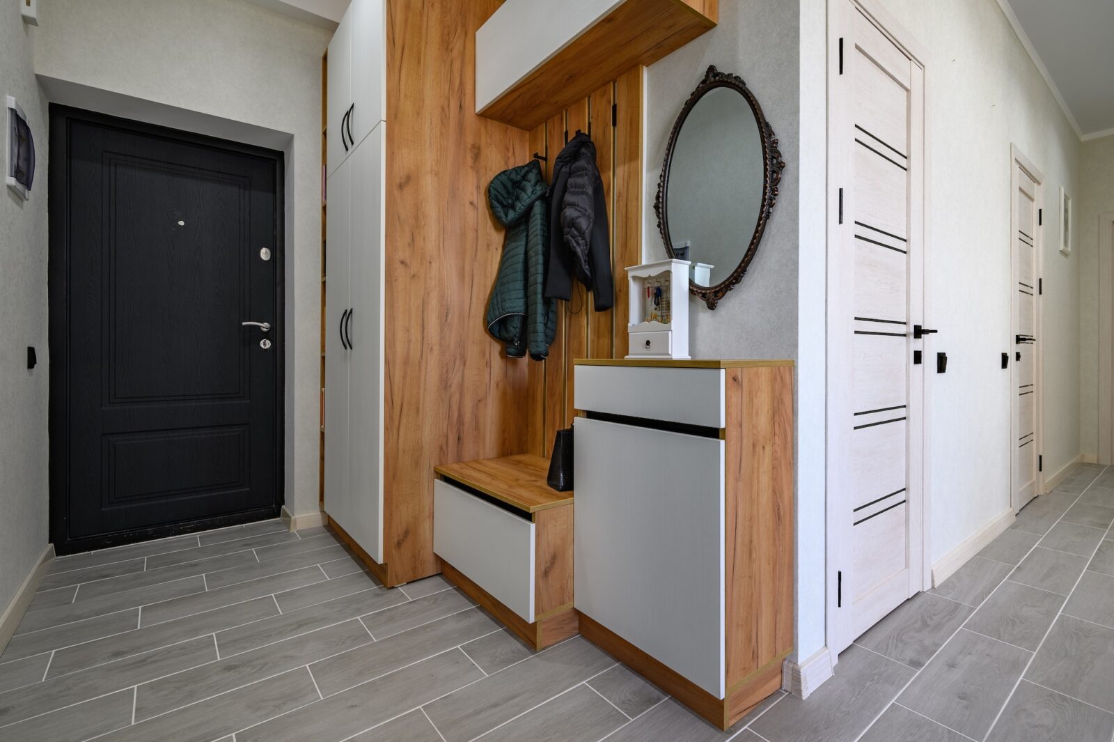 Small entrance hallway interior with shoe storage, hanger stand and mirror