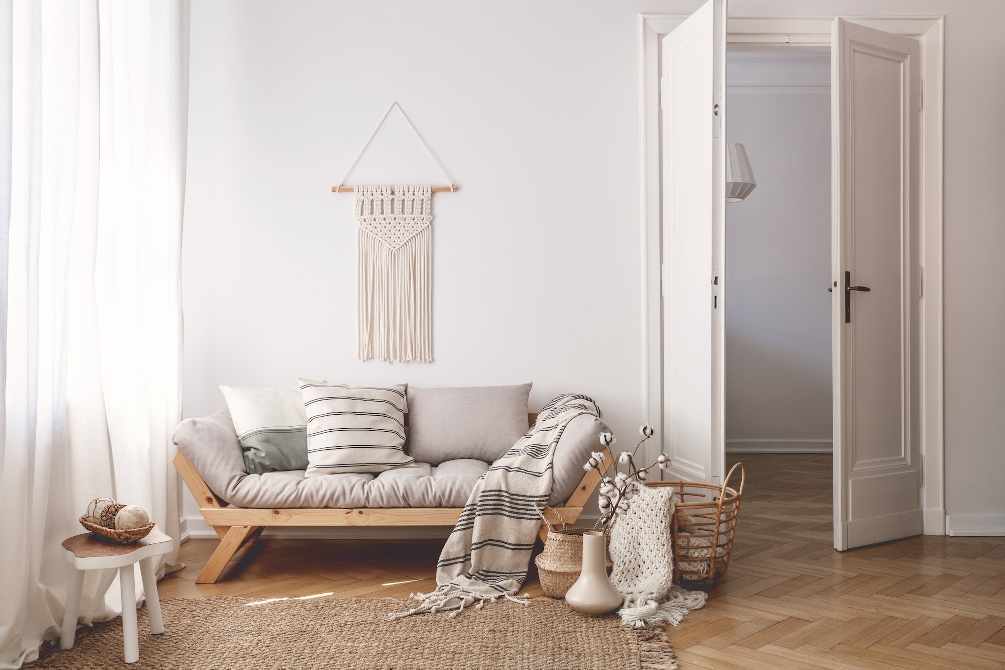 Sunlit living room interior with open door, herringbone parquet
