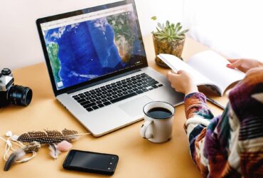 stylish girl with coffee on background of laptop map