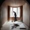 A builder sweeping and tidying up in a renovated replastered house with an archway.