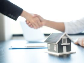 Businessmen and brokers real estate agents shake hand after completing negotiations to buy houses