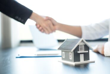 Businessmen and brokers real estate agents shake hand after completing negotiations to buy houses