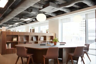 Chairs Around Table In Empty Modern Meeting Area Of Office