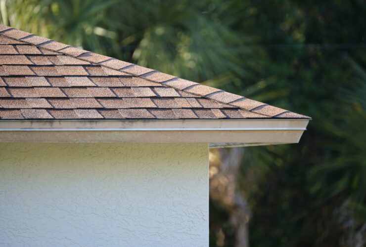 Closeup of house roof top covered with asphalt or bitumen shingles. Waterproofing of new building