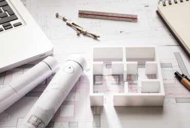 Construction concept. Residential building drawings and house model,