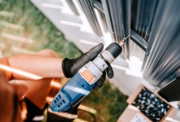 construction worker working with an electric screwdriver on the construction site