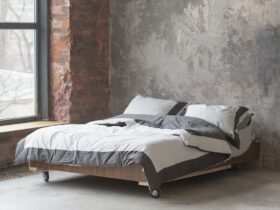 Loft style bedroom interior with bed, gray design, brick texture and concrete wall