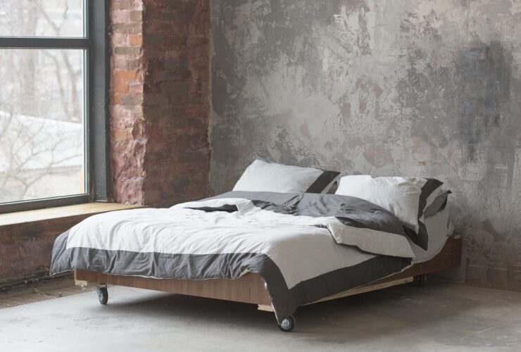 Loft style bedroom interior with bed, gray design, brick texture and concrete wall