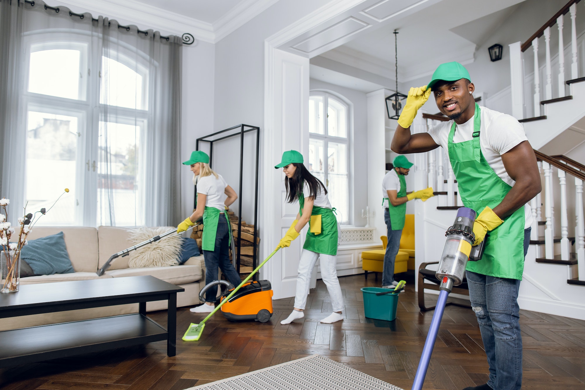 Mixed race janitors doing spring cleaning of house