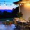 Outdoor living space with dining table set for dinner with wine, lights and a view of the mountains