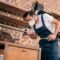 pest control worker spraying pesticides in kitchen and using flashlight