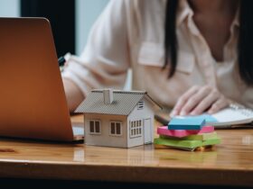 Real estate woman with house model on working desk for investment to buying property