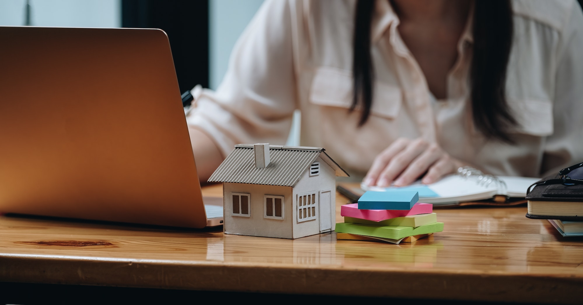 Real estate woman with house model on working desk for investment to buying property