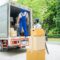 Removal company workers unloading Boxes From Truck Into New Home On Moving Day.