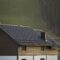 Roof of cottage with siding walls, brown shingle roof and high chimneys in ecological area