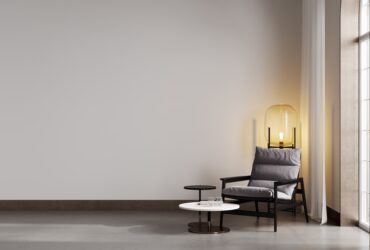 Room with beige wall and concrete floor with gray modern armchair