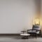 Room with beige wall and concrete floor with gray modern armchair