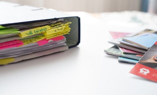 School box-files with organized reading document notes on table. Office supplies